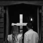 Couple seen from behind entering a church with a cross in Paragominas, Brazil.